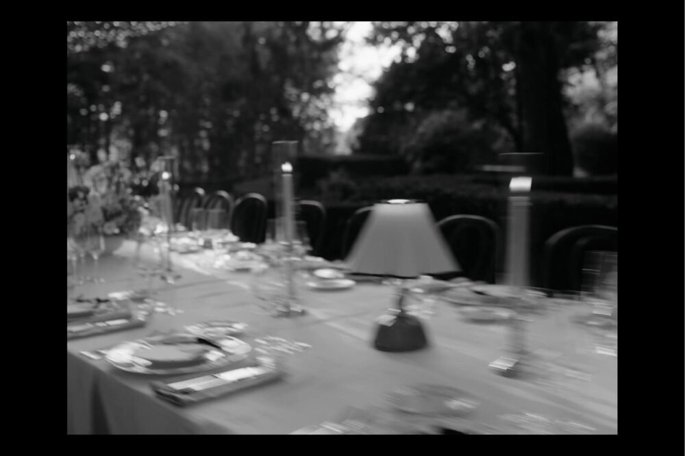 Black and white photograph of an evening dinner table setting at a Tuscan wedding venue